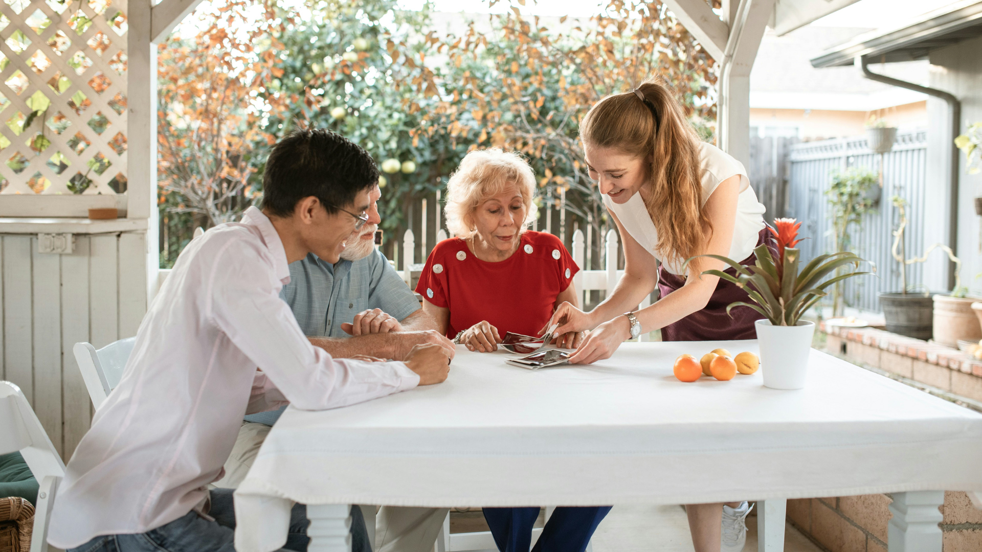 Diverse family gathered outside smiling and looking at pictures
